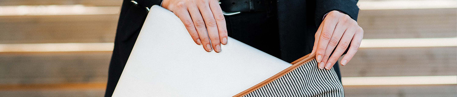 close-up of a hand picking up a laptop from a bag